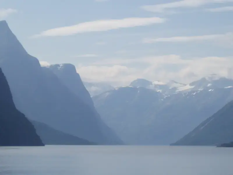 A Norwegian fjord between steep mountains under a light sky