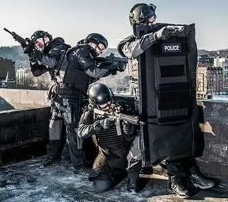 Police team advancing behind a ballistic shield